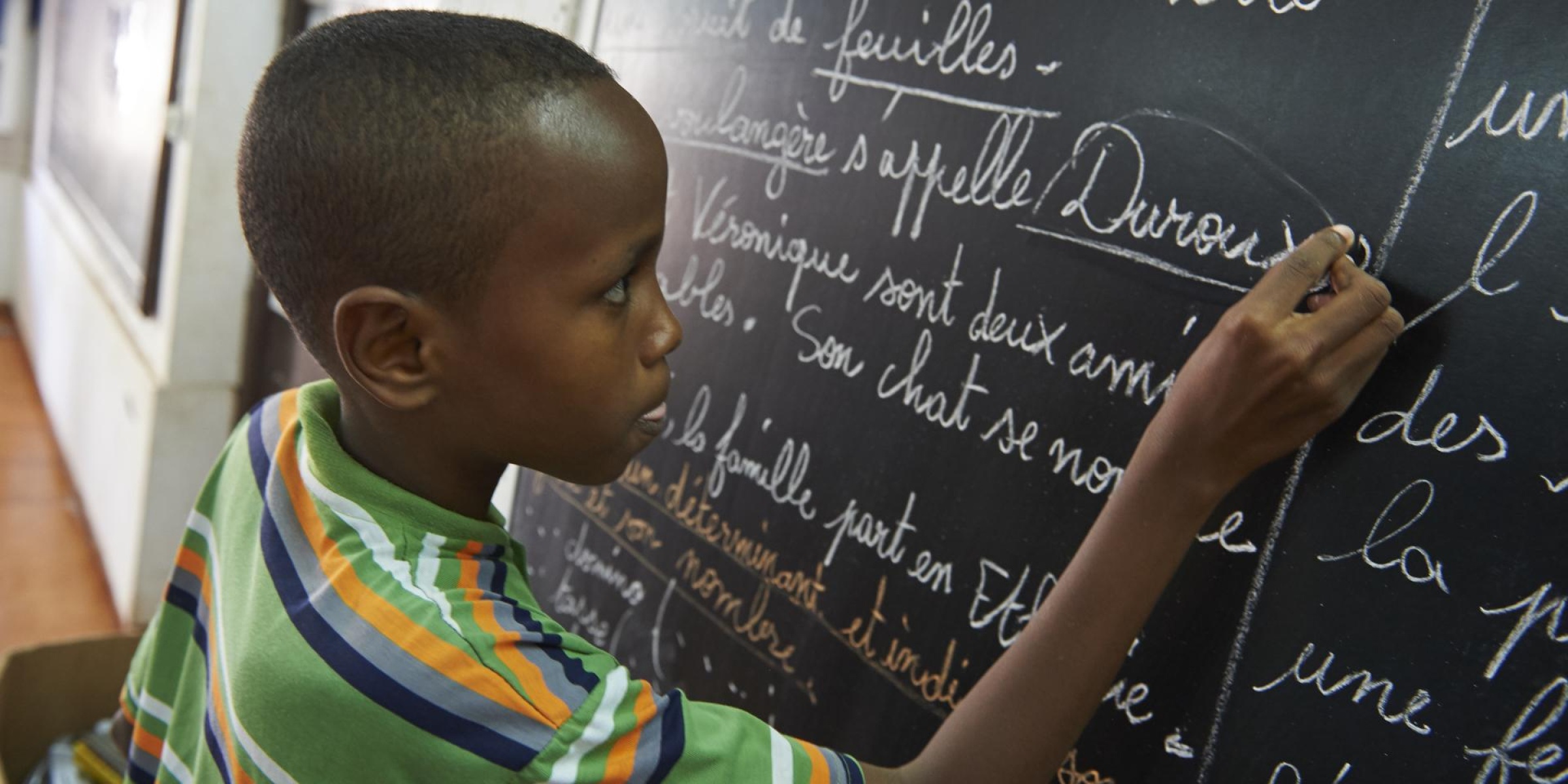A student writing on the blackboard in his classroom. Credit: UNICEF/Djibouti/2018/0054/Noorani
